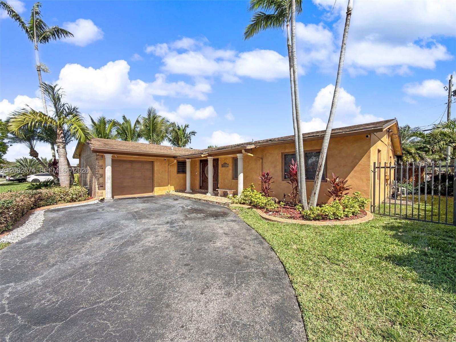 A single-story house with a stucco exterior, a paved driveway, and palm trees — 9837 SW 194th St, Cutler Bay FL 33157, CUTLER BAY, FL