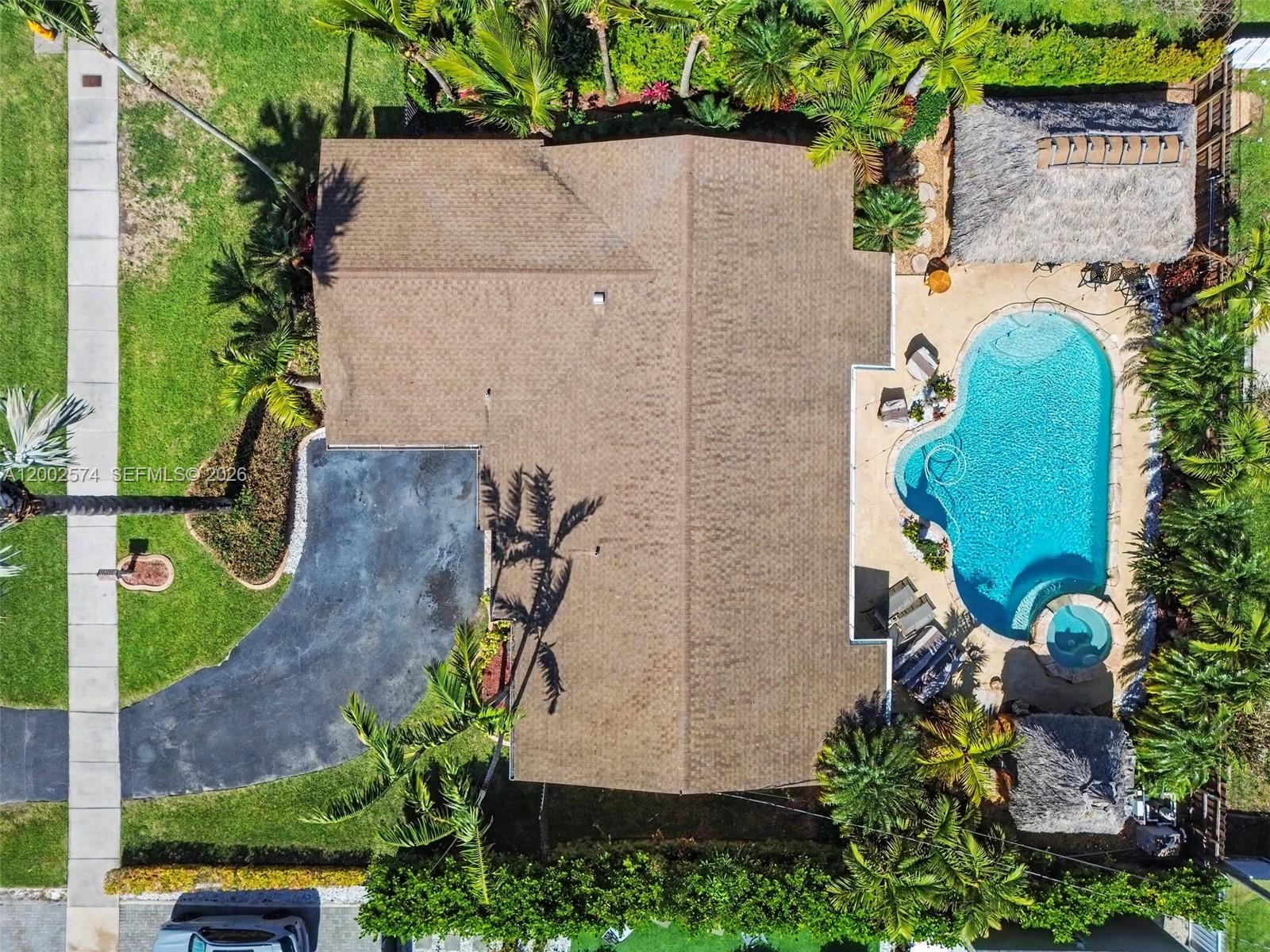 An aerial view shows a house with a brown roof, a pool, and a tiki hut — 9837 SW 194th St, Cutler Bay FL 33157, CUTLER BAY, FL