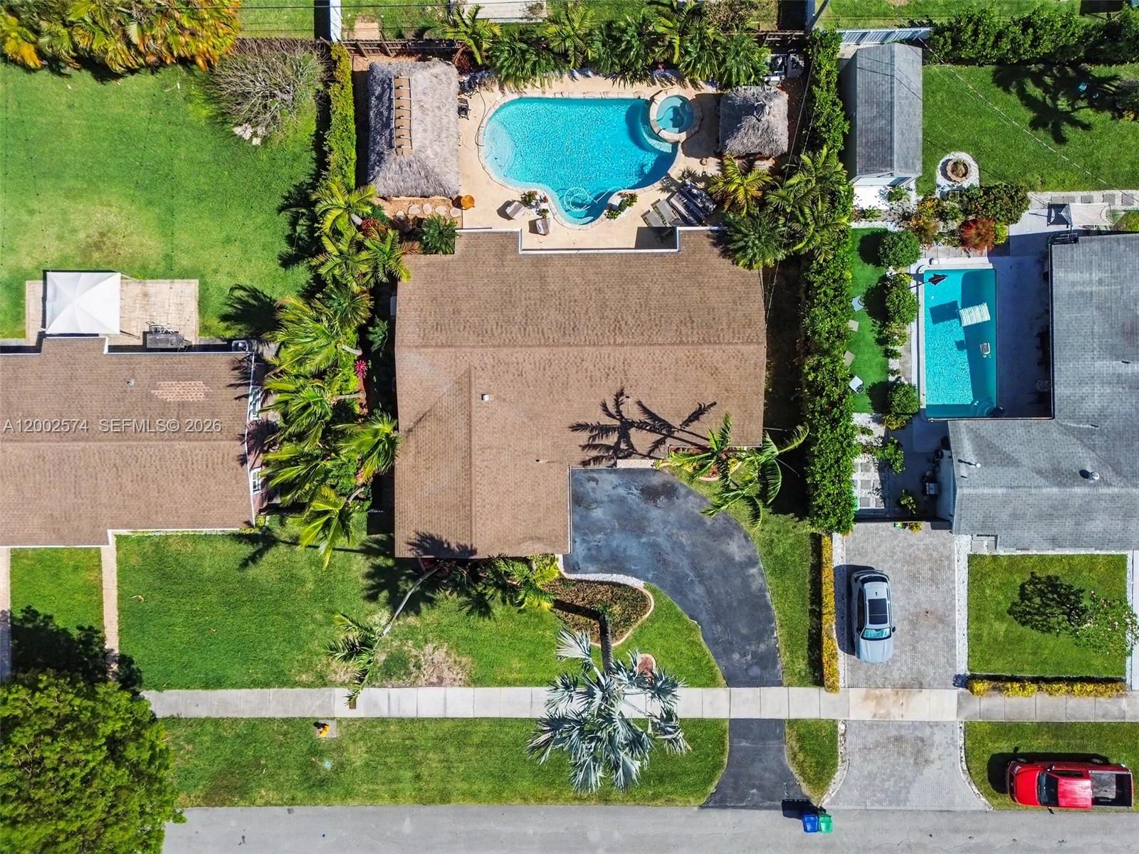 An aerial view shows a house with a pool, tiki hut, and driveway in Florida — 9837 SW 194th St, Cutler Bay FL 33157, CUTLER BAY, FL