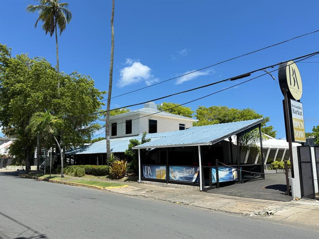 A two-story building with a blue metal roof and an outdoor patio area — Punta Las Marias 33 & 35 CAOBA, SAN JUAN, PR