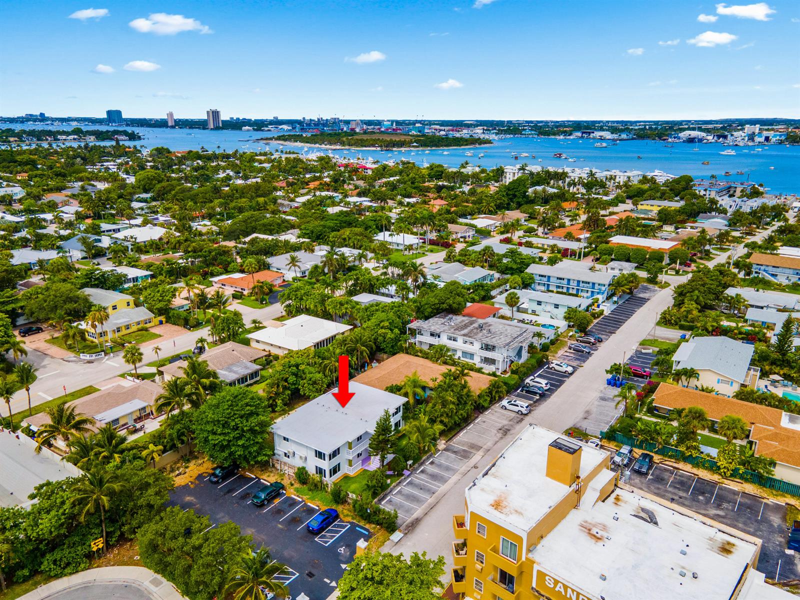 An aerial view shows a multi-story apartment building with a parking lot and surrounding neighborhood — 1279 Beach Road # 3, West Palm Beach FL 33404, WEST PALM BEACH, FL