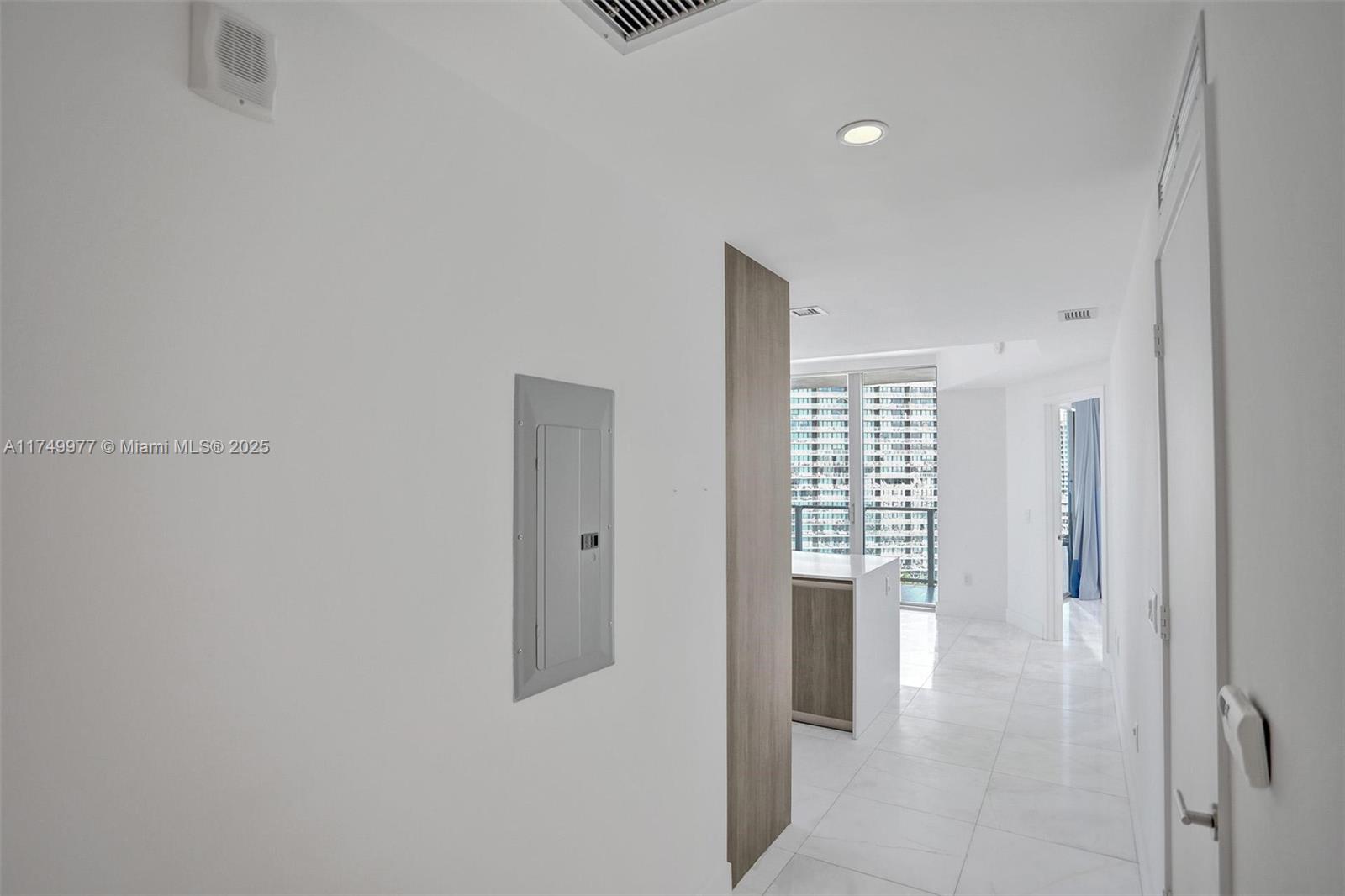 A white hallway leads to an open living area with floor-to-ceiling windows and tile flooring — 2900 NE 7th Ave # 1601, Miami FL 33137, MIAMI, FL