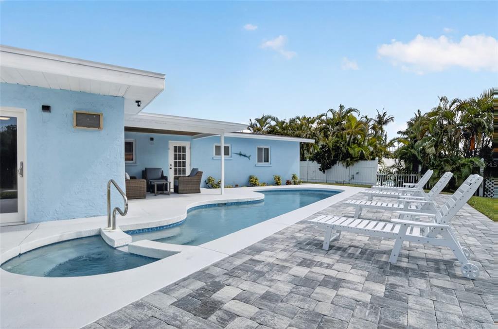 A light blue house features a swimming pool with an attached spa and patio furniture — 507 59TH STREET, BRADENTON BEACH, FL