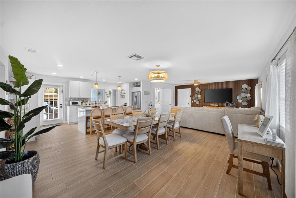 An open-concept living area features a kitchen, dining table, and living room with wood-look flooring — 507 59TH STREET, BRADENTON BEACH, FL
