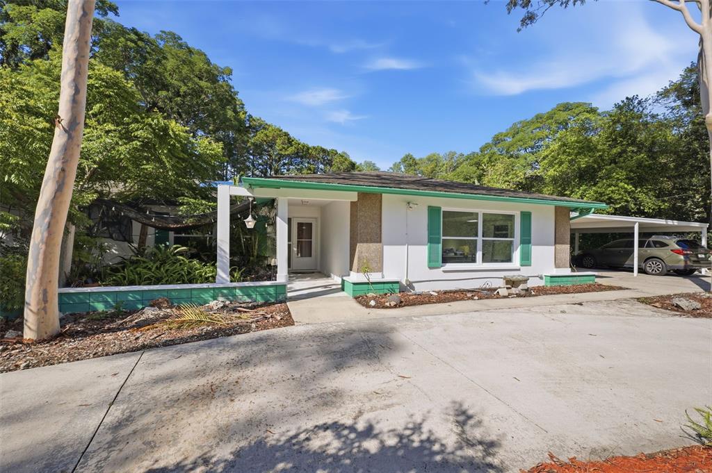 A single-story house with a white exterior, green shutters, and a covered carport — 9116 LAKEVIEW DRIVE, NEW PORT RICHEY, FL