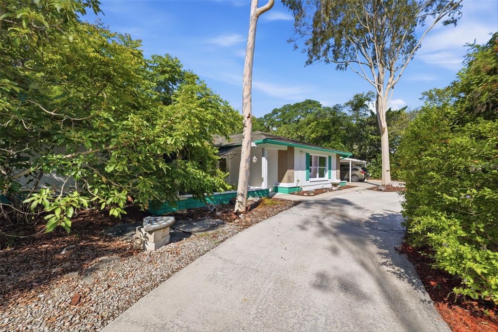 A single-story house with a concrete driveway, green trim, and mature trees in the yard — 9116 LAKEVIEW DRIVE, NEW PORT RICHEY, FL