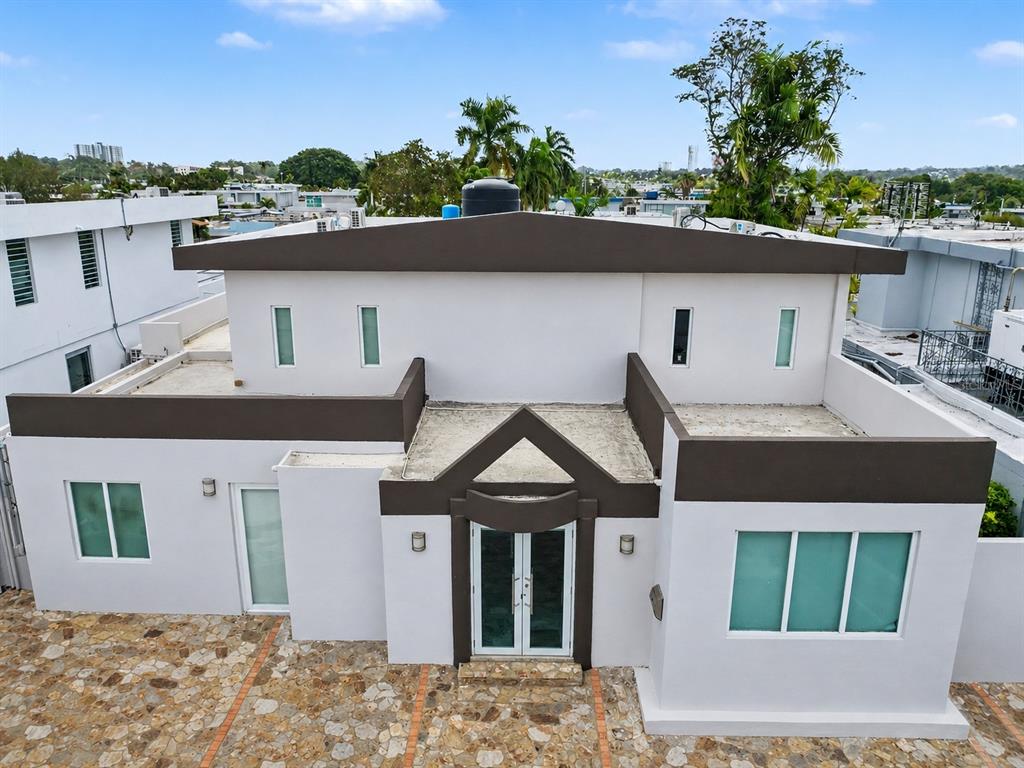An exterior view of a two-story white house with brown trim and a stone driveway — C7 AVE ACUARELA, GUAYNABO, PR