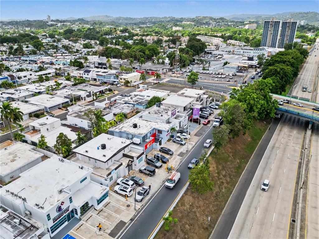 An aerial view shows a commercial building with a parking lot beside a highway — C7 AVE ACUARELA, GUAYNABO, PR