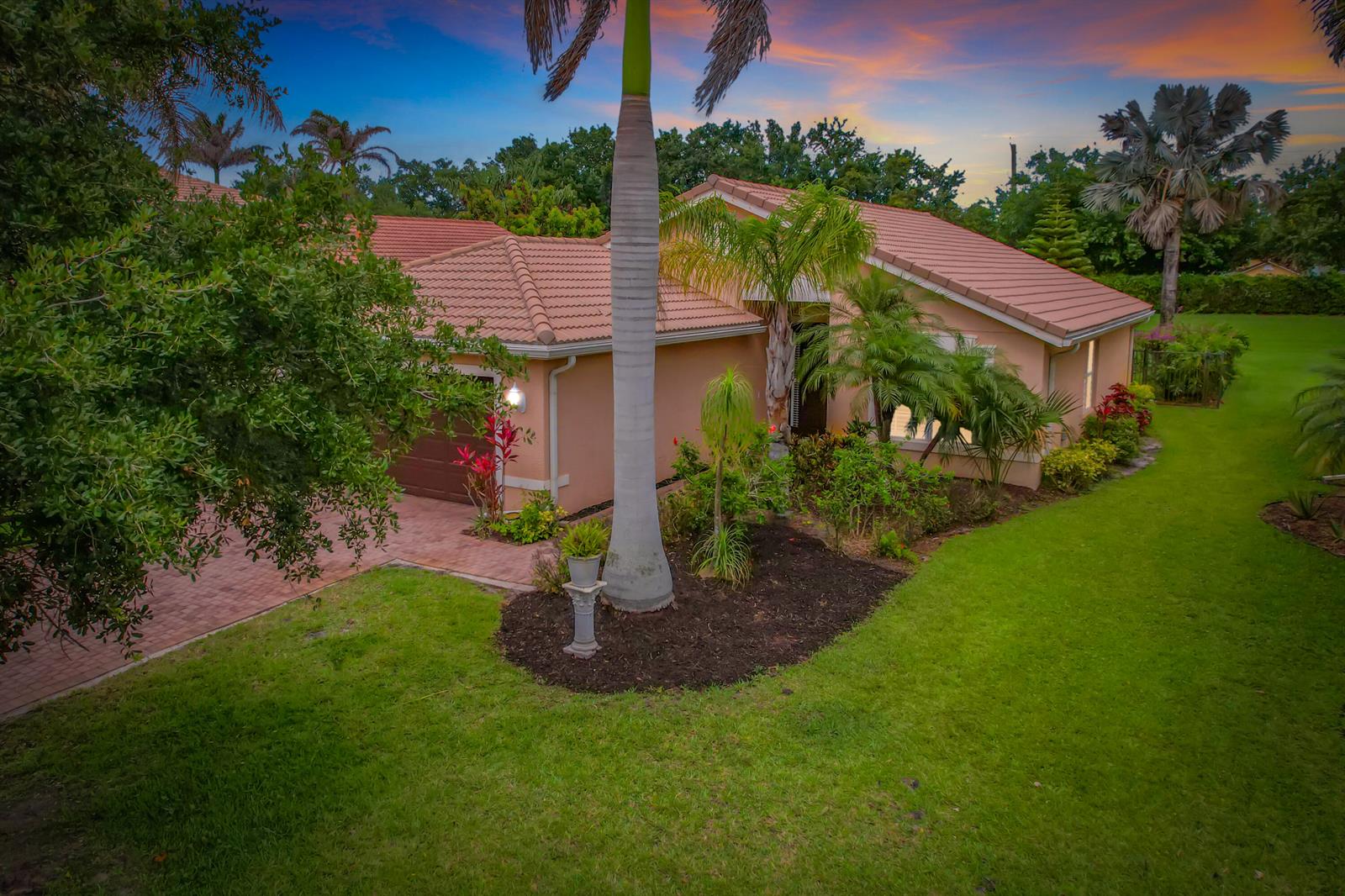 An aerial view of a single-story house with a tiled roof, palm trees, and landscaping — 2045 Grey Falcon Circle SW, Vero Beach FL 32962, VERO BEACH, FL
