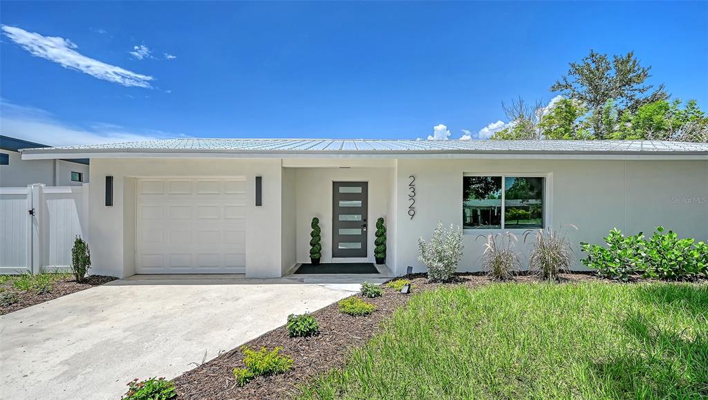 A single-story house with a white exterior, a garage, and a front lawn — 2329 ROSE STREET, SARASOTA, FL