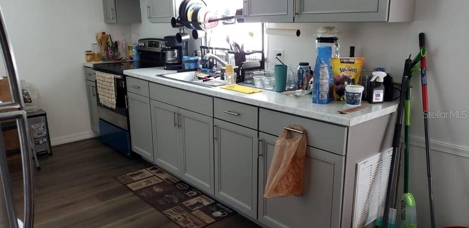 A kitchen features gray cabinets, a white countertop, and a stainless steel oven — 1089 GREENSKEEP DRIVE, KISSIMMEE, FL