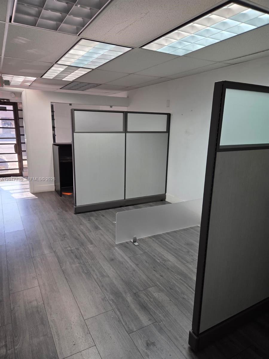 An office space features gray wood-look flooring, modular cubicle partitions, and recessed ceiling lights — 7274 NW 70th St, Miami FL 33166, MIAMI, FL