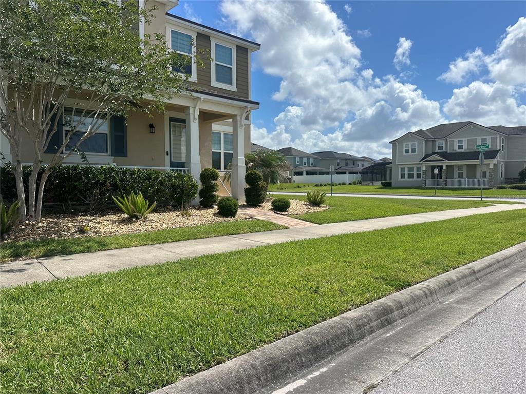 A two-story suburban house with a tan exterior, front porch, and landscaped yard — 2791 RAPOLLO DRIVE, KISSIMMEE, FL