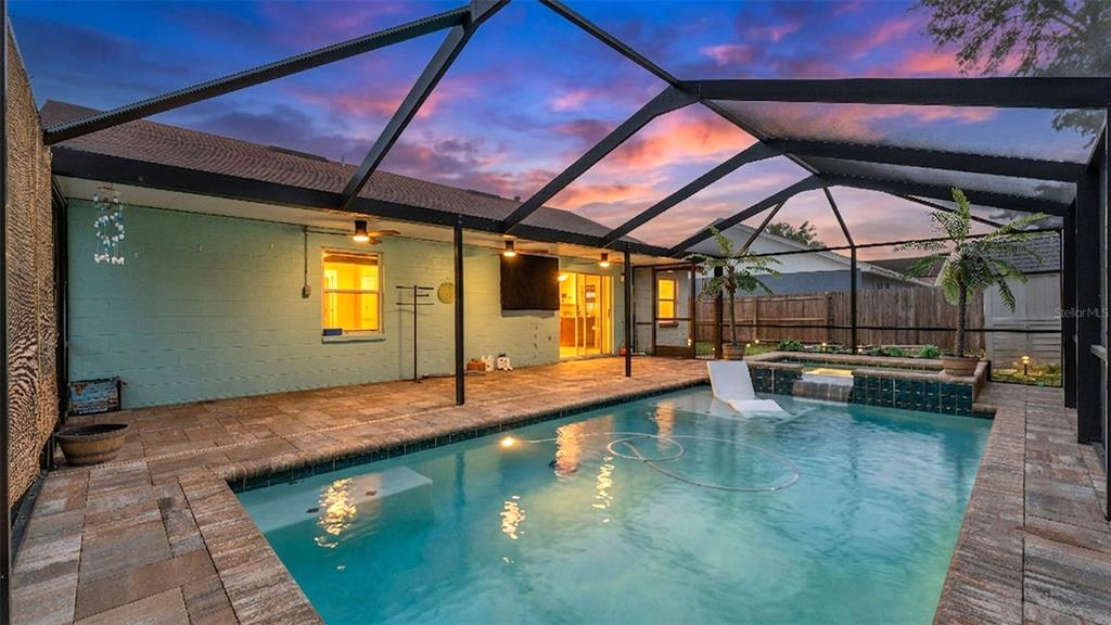 A screened-in patio features a swimming pool with a tanning ledge and a hot tub — 3312 QUEENS COVE LOOP, WINTER HAVEN, FL