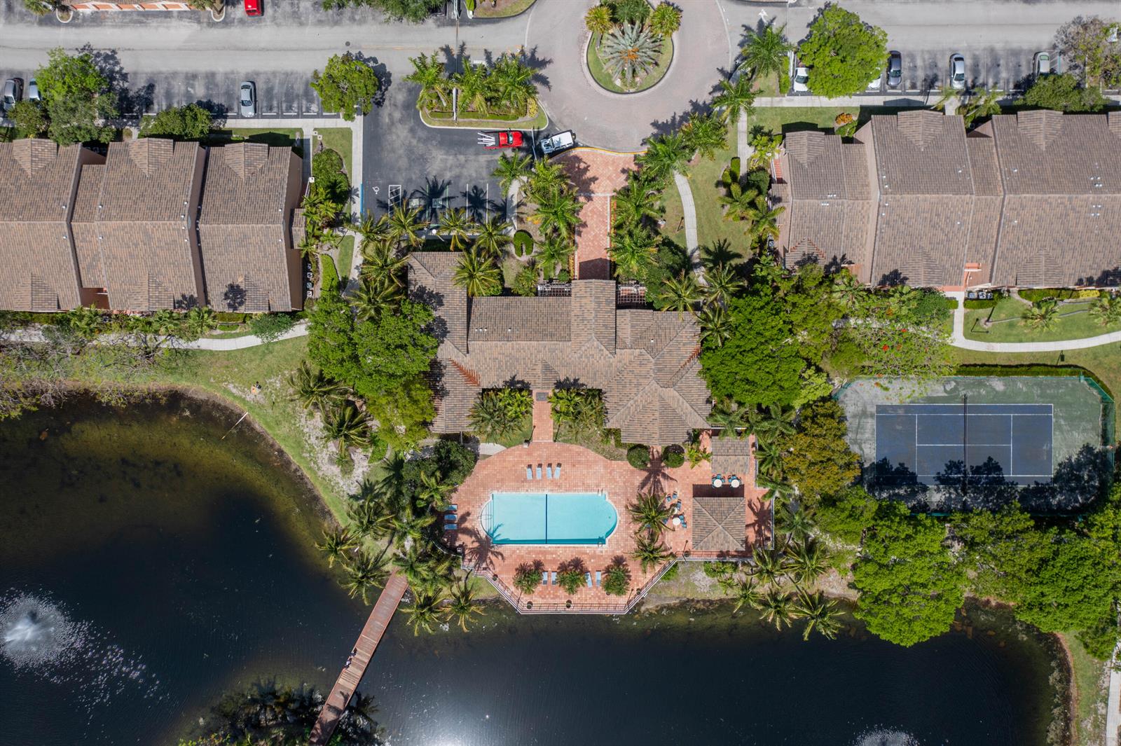 An aerial view shows a community clubhouse with a pool, tennis court, and lake — 3844 Lyons Road # 4, Coconut Creek FL 33073, COCONUT CREEK, FL