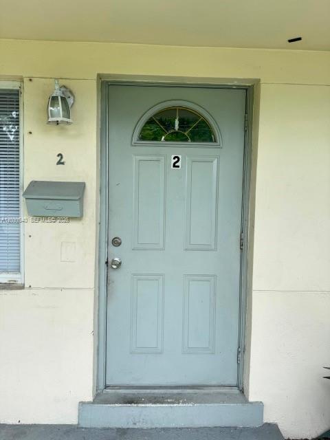 A light gray front door with a small window and the number two is shown — NORTH MIAMI BEACH, FL
