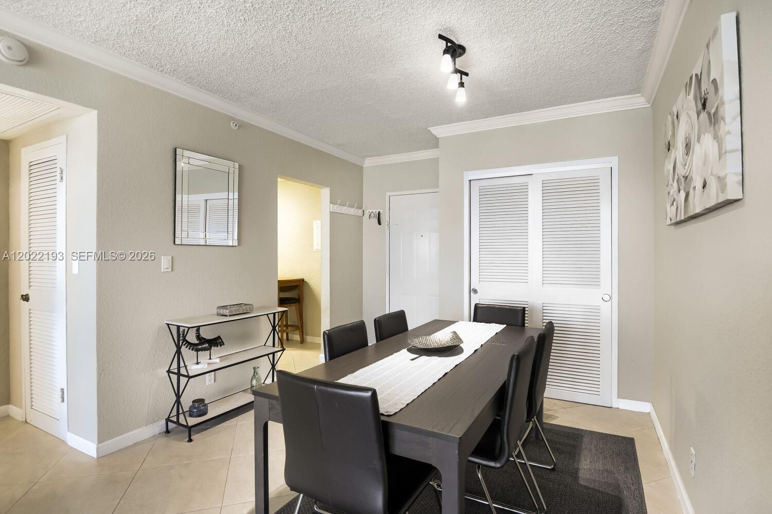 A dining room features a dark wood table, six chairs, and white louvered closet doors — 2501 S Ocean Dr # 1129, Hollywood FL 33019, HOLLYWOOD, FL