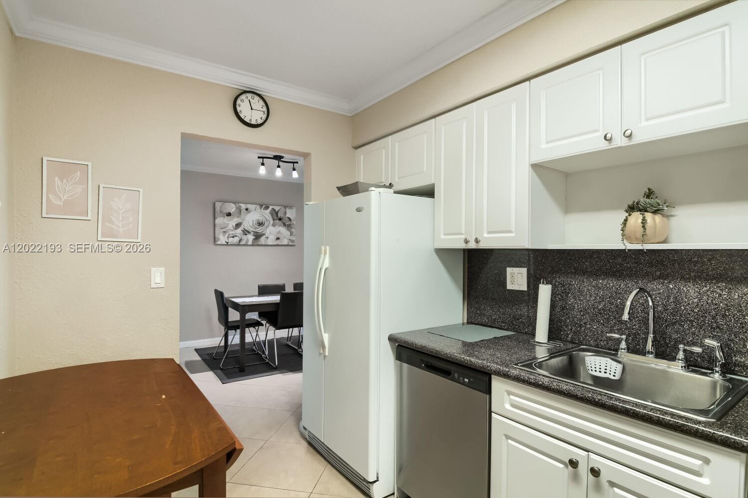 A kitchen features white cabinets, a dark countertop, a stainless steel sink, and a refrigerator — 2501 S Ocean Dr # 1129, Hollywood FL 33019, HOLLYWOOD, FL