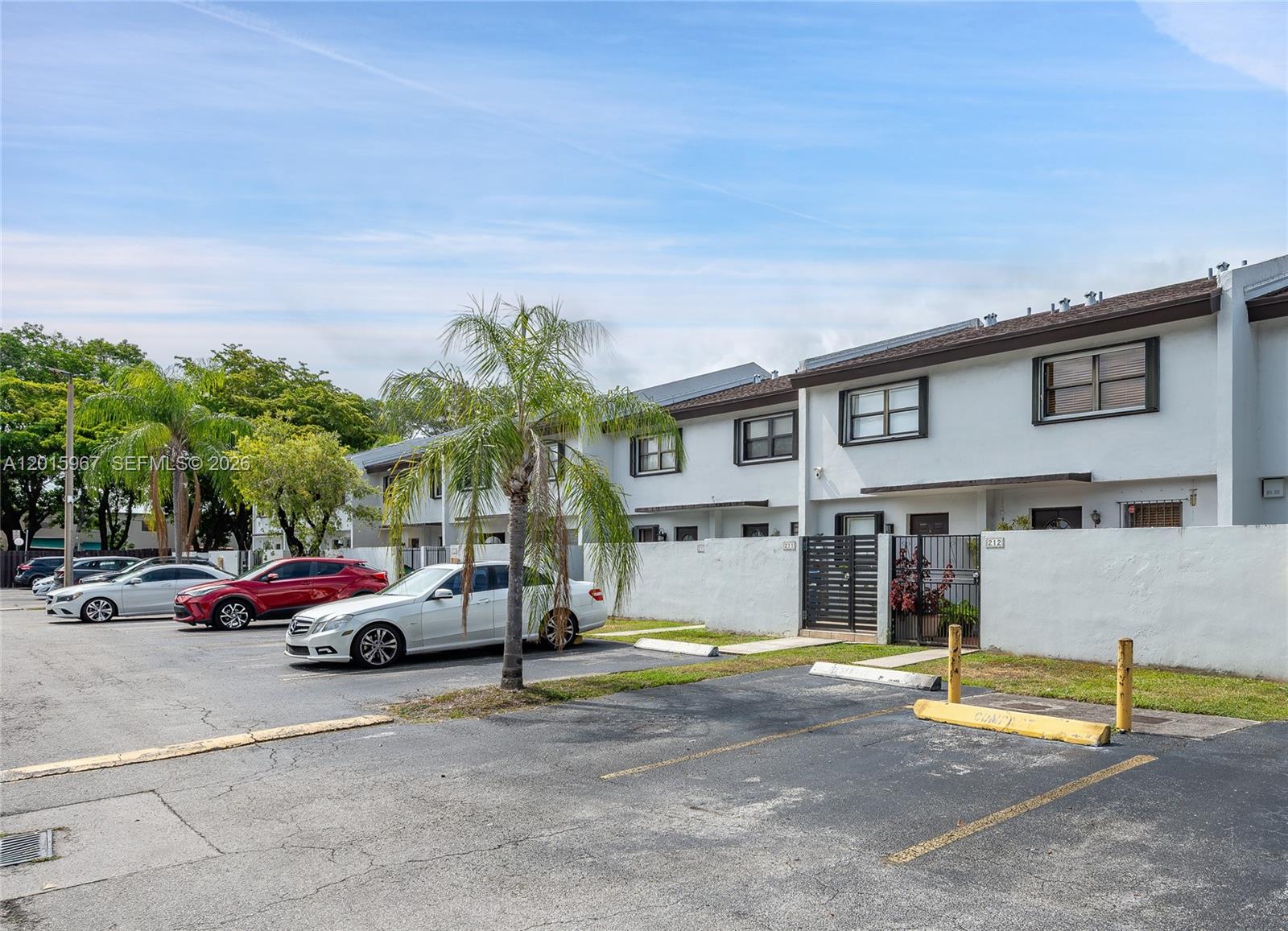 A row of two-story townhouses with white walls and a parking lot in front — 8010 SW 152nd Ave # 211, Miami FL 33193, MIAMI, FL