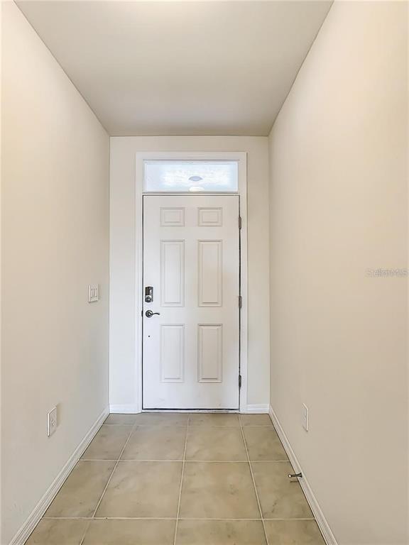An entryway features a white door with a transom window and light-colored tile flooring — 4203 MANATEE LANE, PUNTA GORDA, FL