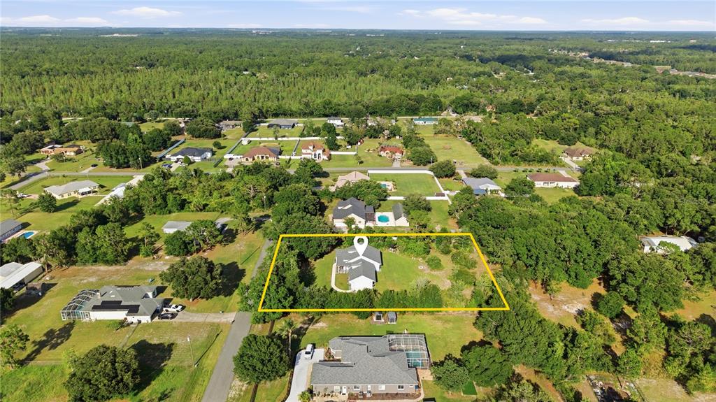 An aerial view shows a house with a white roof highlighted by a yellow border — 26644 EASY STREET, WESLEY CHAPEL, FL