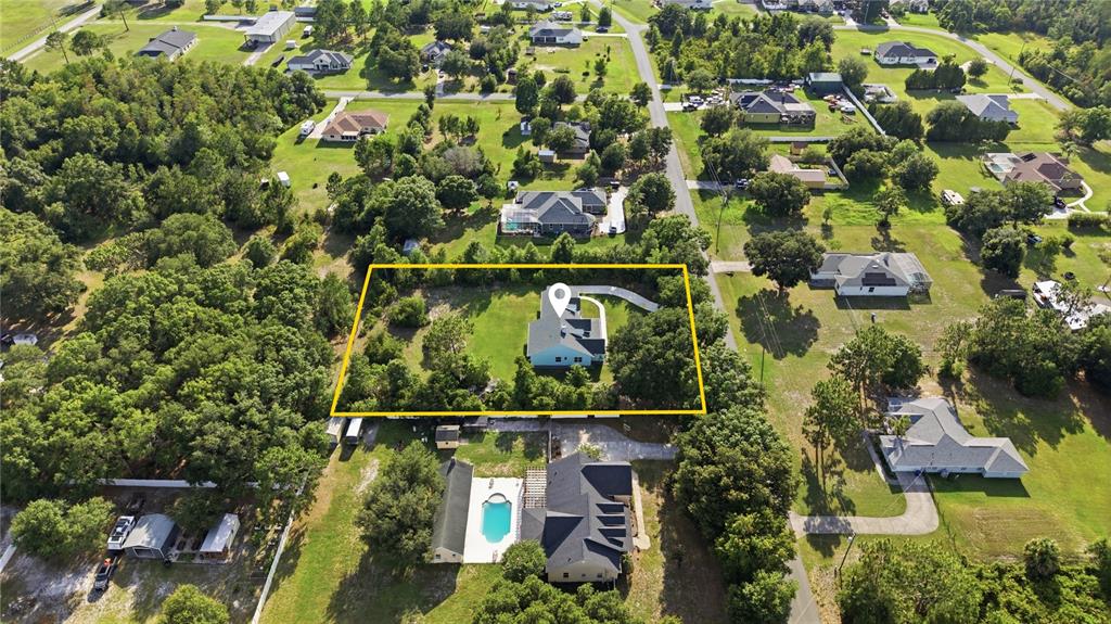 An aerial view shows a house with a yellow outline on a wooded residential lot — 26644 EASY STREET, WESLEY CHAPEL, FL