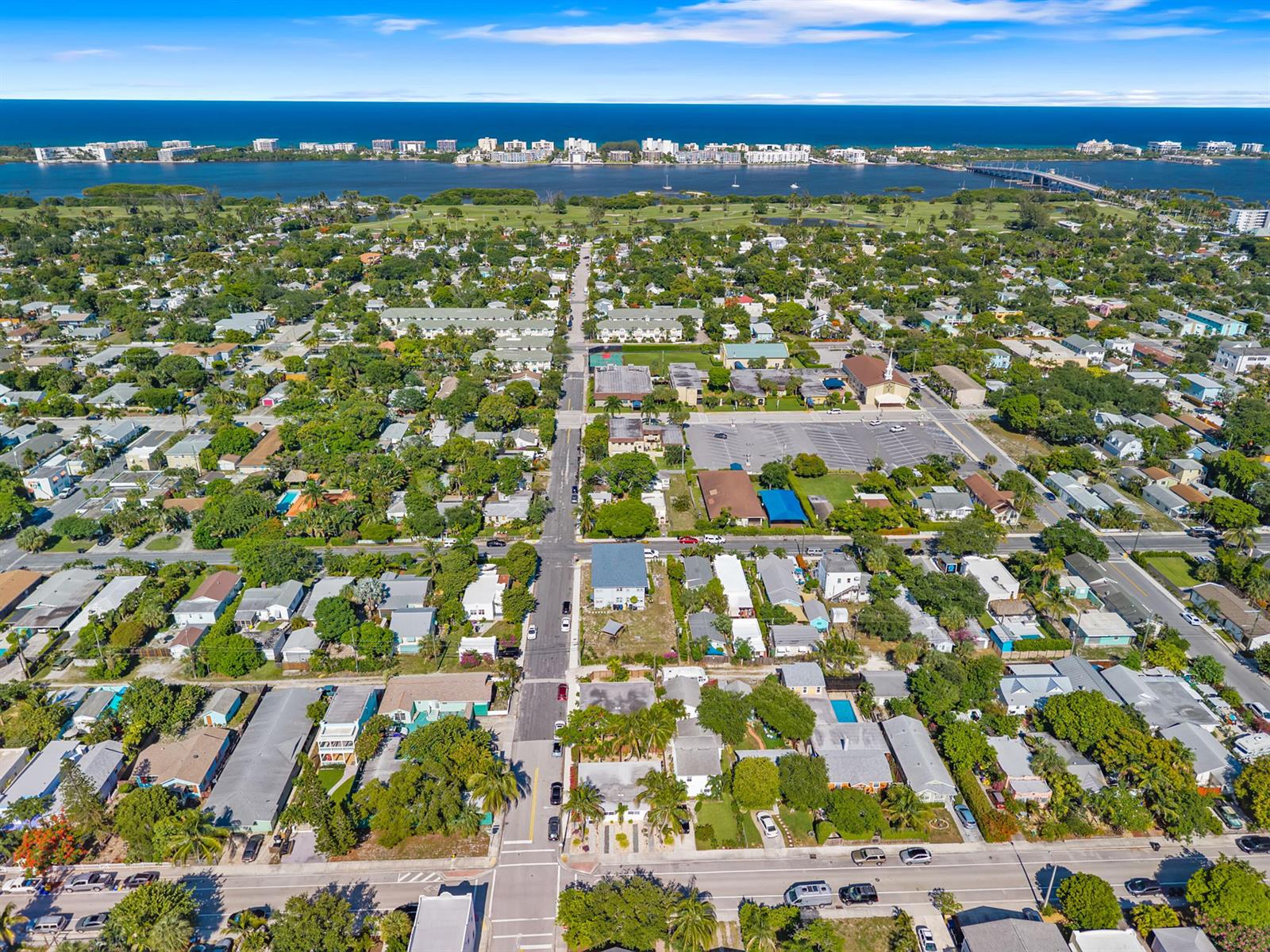An aerial view shows a coastal neighborhood with houses, streets, and a distant bridge — 430 N K Street, FL 33460, FL