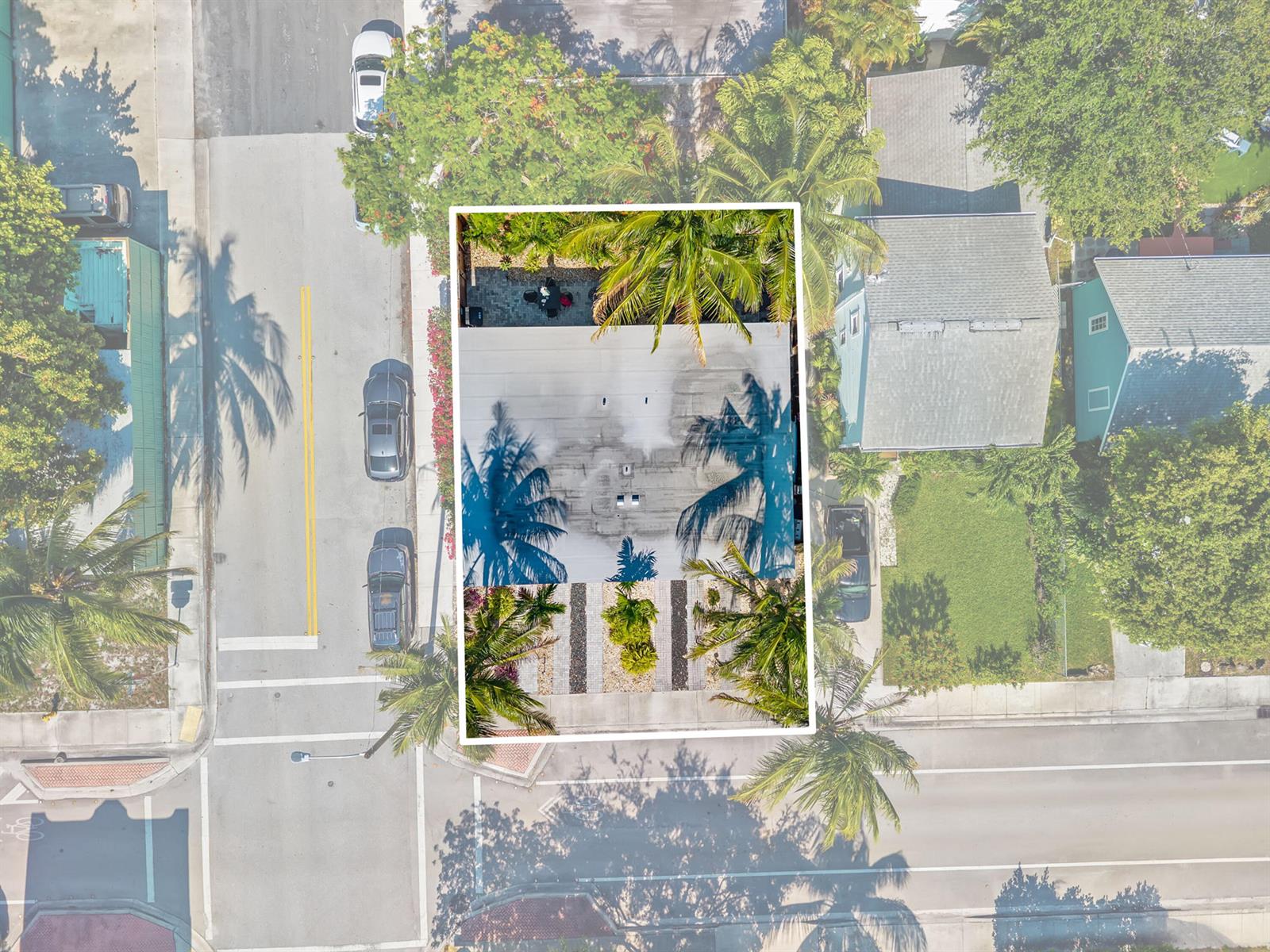 An aerial view shows a flat-roofed house with palm trees and a paved backyard area — 430 N K Street, FL 33460, FL