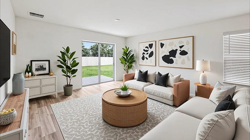 This is a rendering of a living room with a sofa, coffee table, and sliding doors — 9113 SW 47TH COURT, OCALA, FL