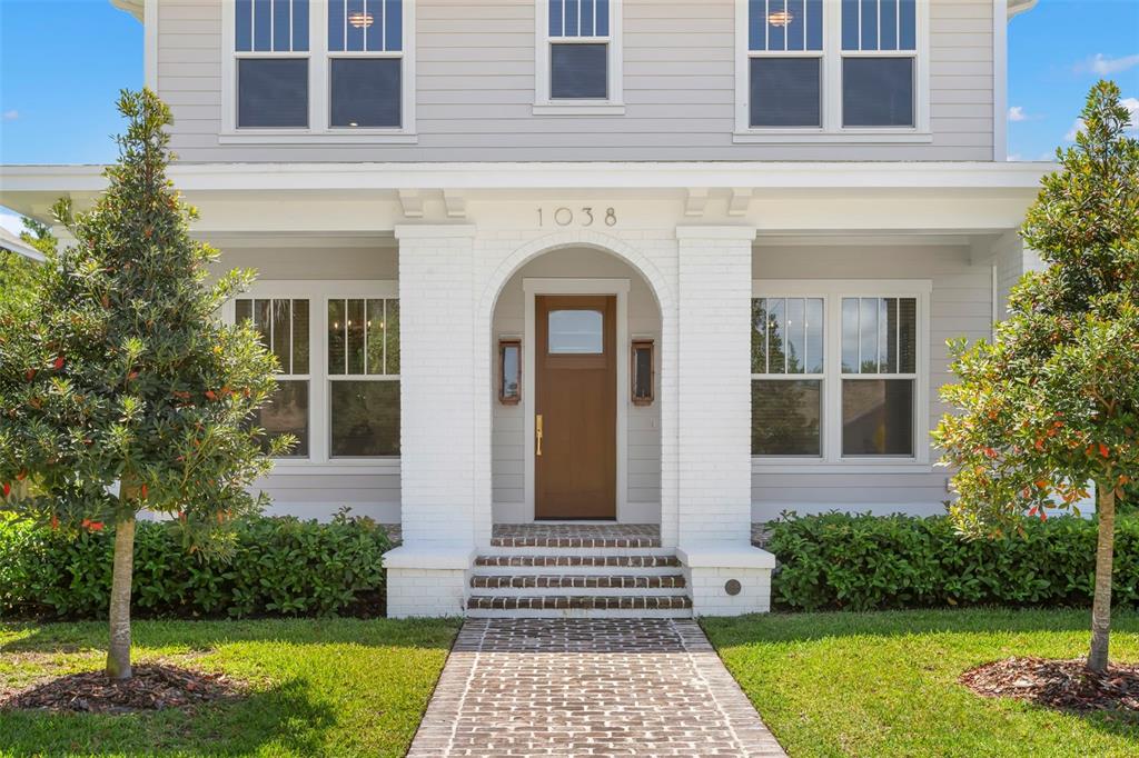 A front view of a two-story house with a brick walkway and arched entryway — 1038 26TH AVENUE N, ST PETERSBURG, FL