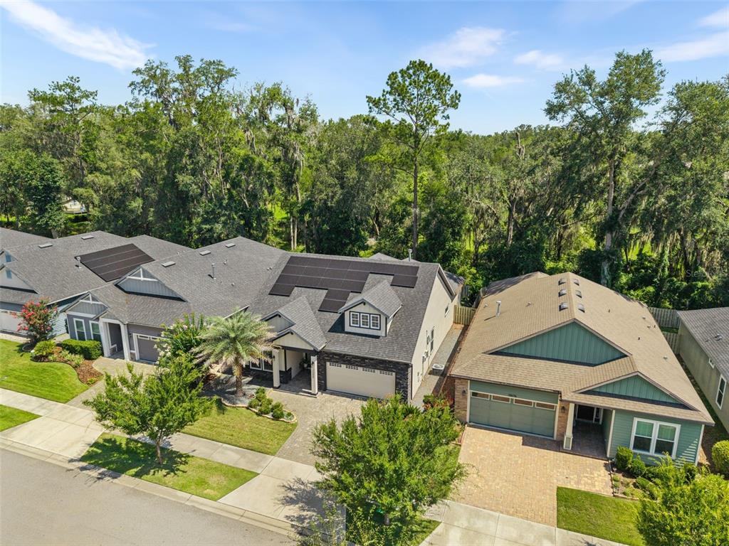 An aerial view shows two adjacent suburban houses with paved driveways and surrounding trees — 13688 NW 12TH PLACE, NEWBERRY, FL