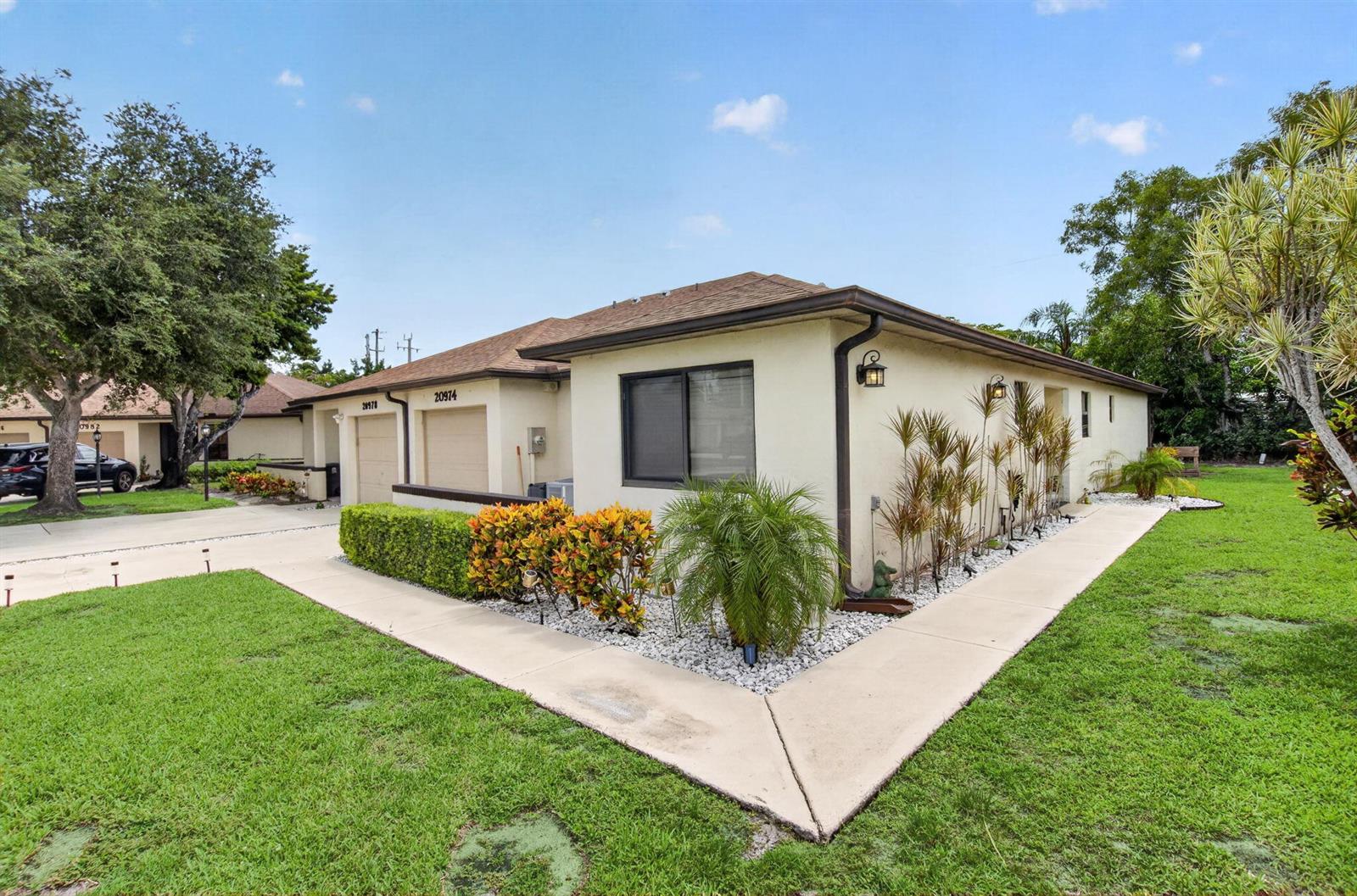 A single-story residential building with a tan stucco exterior, a garage, and landscaped yard — 20974 Concord Green Drive E, Boca Raton FL 33433, BOCA RATON, FL