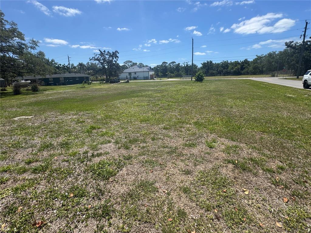 An expansive, grassy vacant lot under a blue sky with scattered clouds — BONITO AVENUE, NOKOMIS, FL