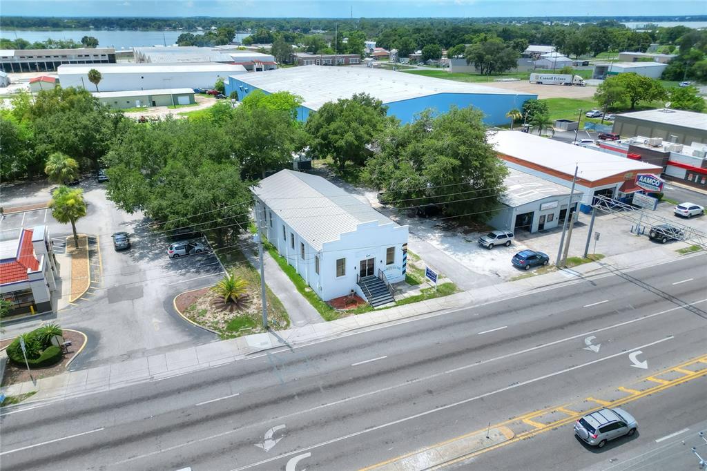 An aerial view shows a white commercial building situated between a parking lot and road — 1649 3RD STREET SW, WINTER HAVEN, FL
