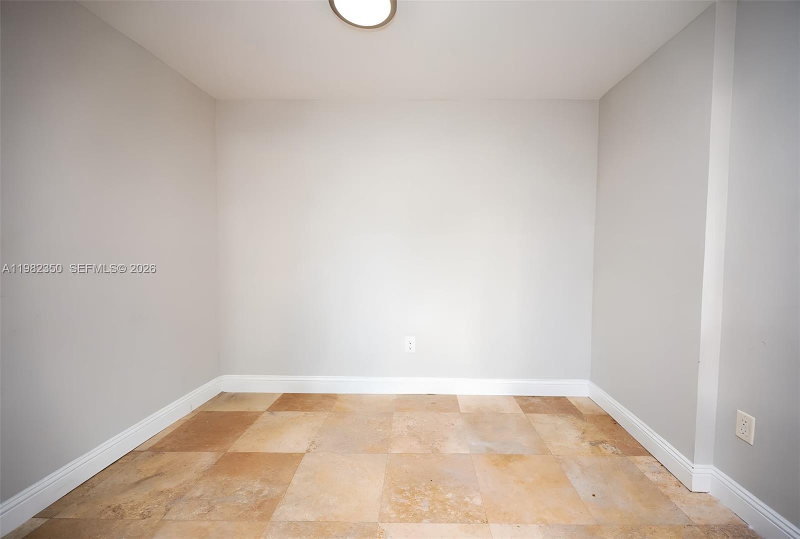 An empty room with light gray walls, white baseboards, and tan square floor tiles — 350 S MIAMI # 1709, Miami FL 33130, MIAMI, FL