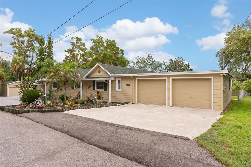 A tan single-story house with a two-car garage and a concrete driveway — 10519 BRIDGEWOOD DRIVE, RIVERVIEW, FL