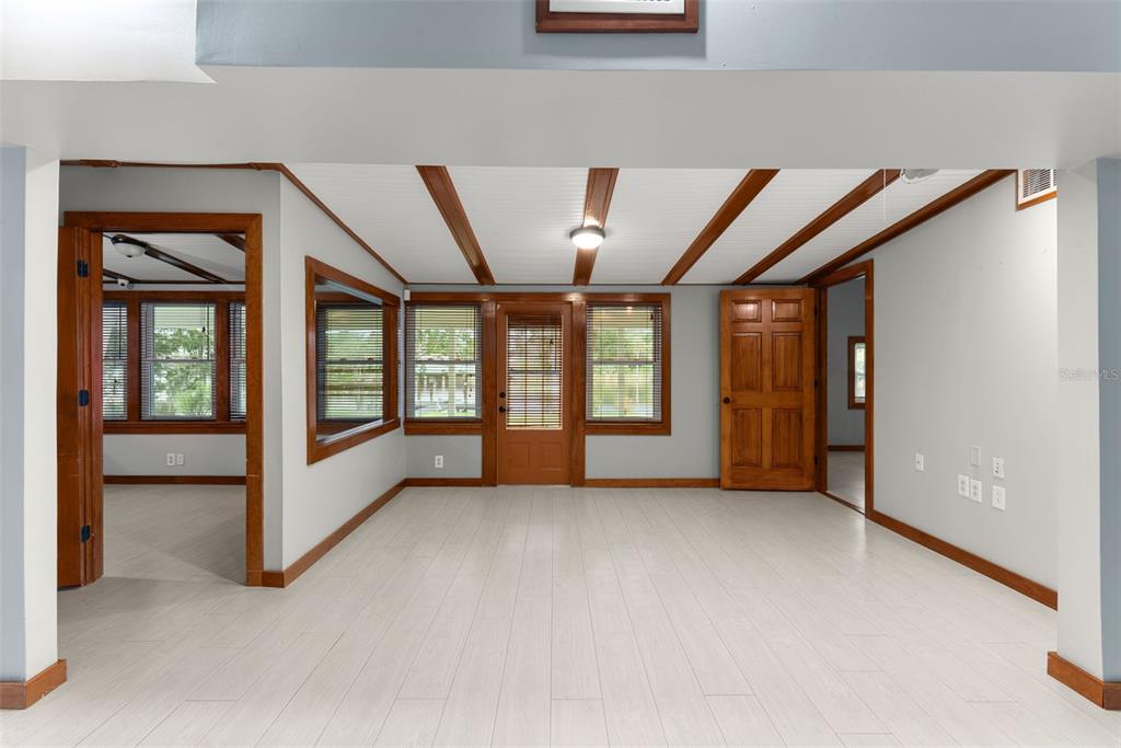 A room with light wood-look flooring, white paneled ceiling with wood beams, and wood-trimmed windows — 10519 BRIDGEWOOD DRIVE, RIVERVIEW, FL