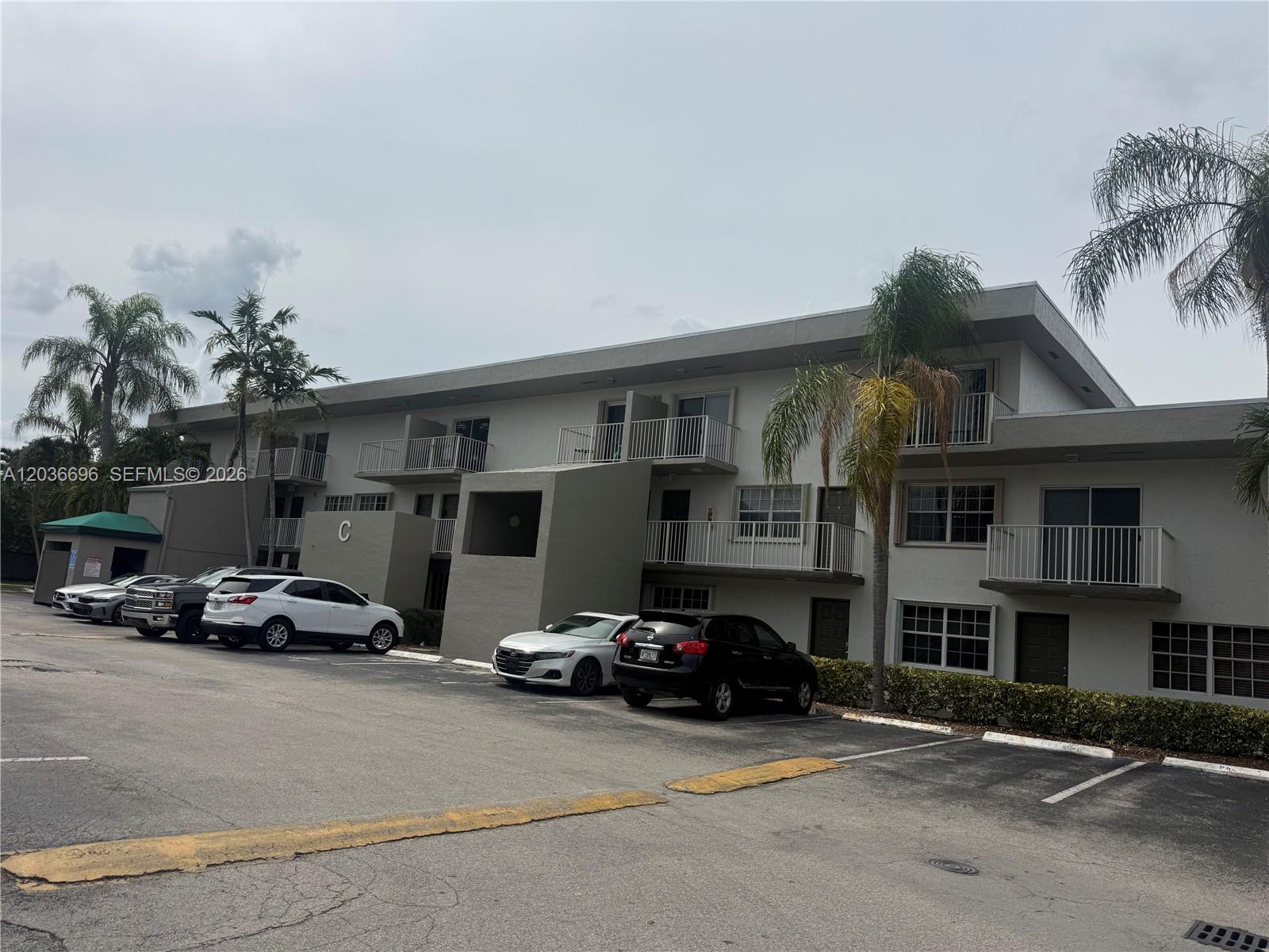 A multi-story apartment building with balconies and a parking lot in front — 7510 SW 152nd Ave # B202, Miami FL 33193, MIAMI, FL
