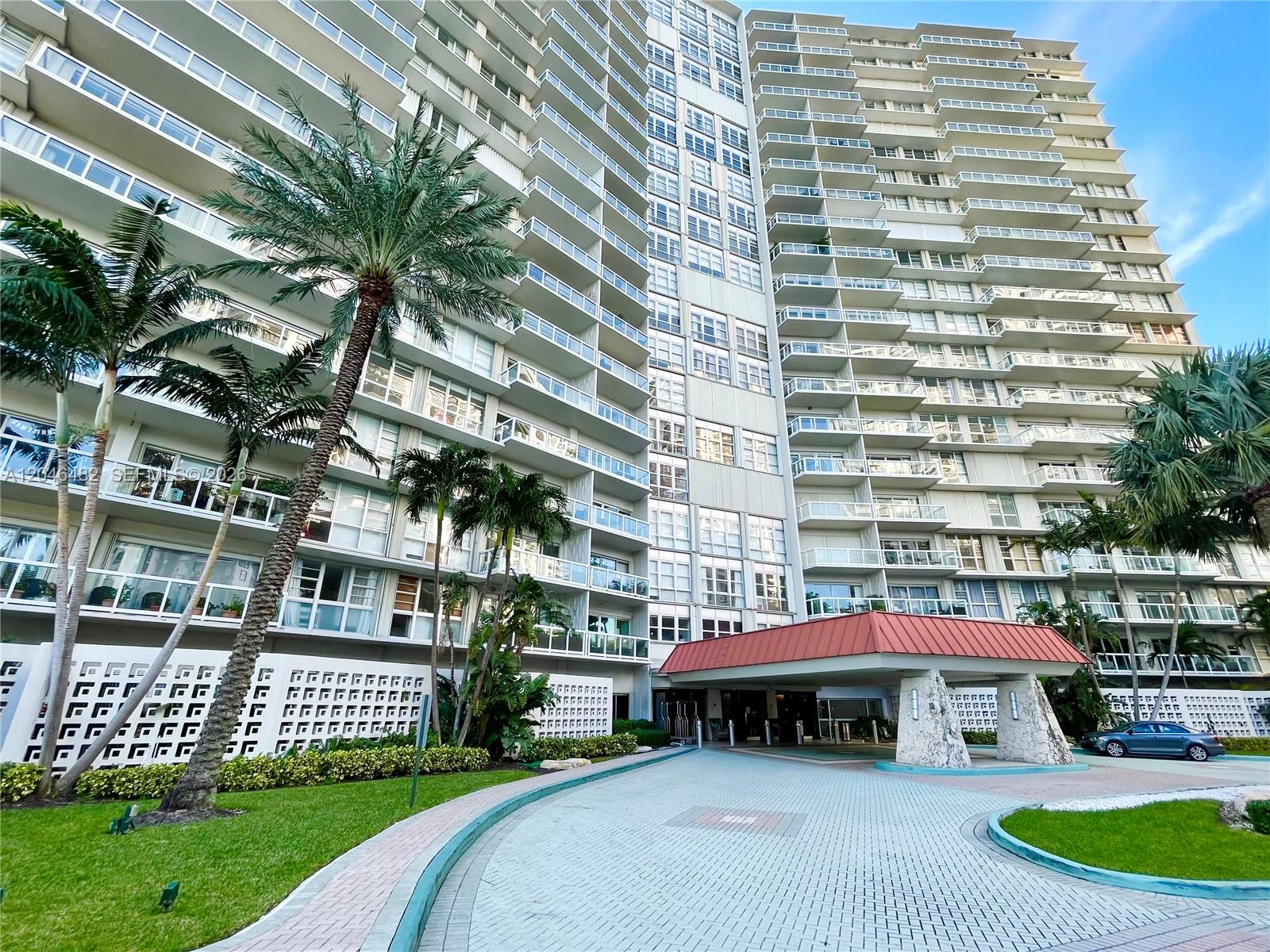 A tall residential apartment building features a covered entrance and palm trees in front — 2451 Brickell Ave # 19B, Miami FL 33129, MIAMI, FL