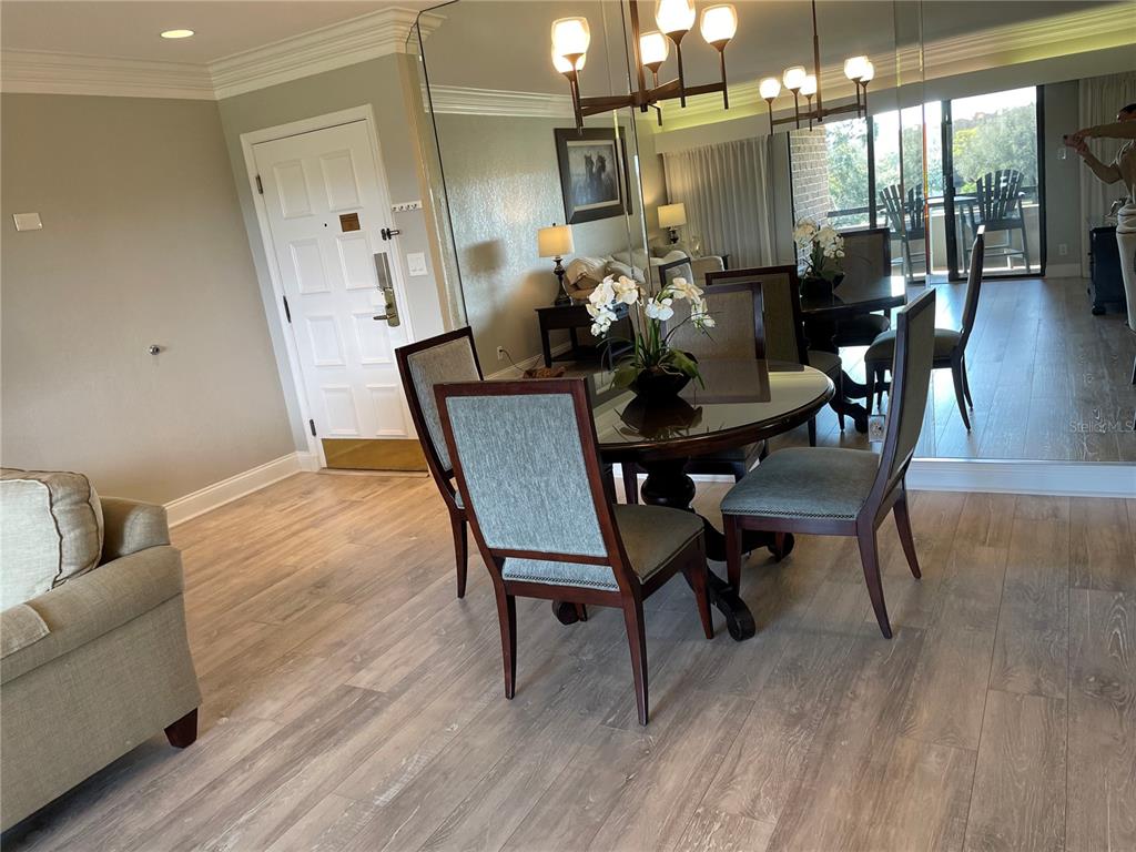 A dining area features a glass-topped table, four upholstered chairs, and a large mirrored wall — 36750 US HIGHWAY 19 N UNIT 14-211, PALM HARBOR, FL