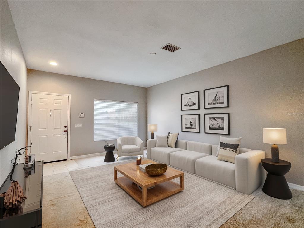 A living room features a light-colored sofa, a wooden coffee table, and framed wall art — 267 CAPE HARBOUR LOOP UNIT 103, BRADENTON, FL