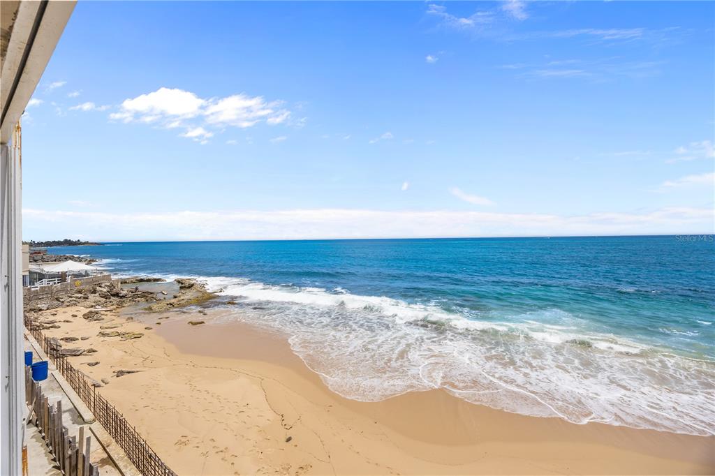 An elevated view of a sandy beach and ocean waves from a balcony — 1035 AVE ASHFORD UNIT 302, SAN JUAN, PR