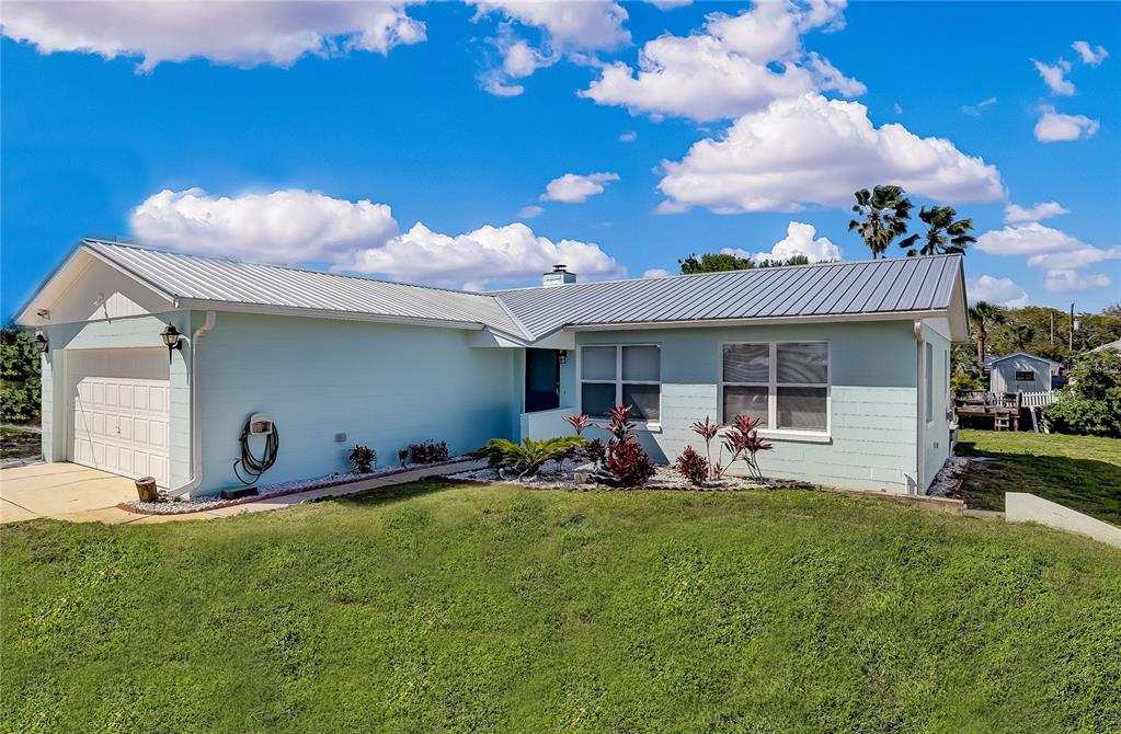 A light blue, single-story house with a metal roof and an attached garage — 260 VENTURA ROAD, ST AUGUSTINE, FL