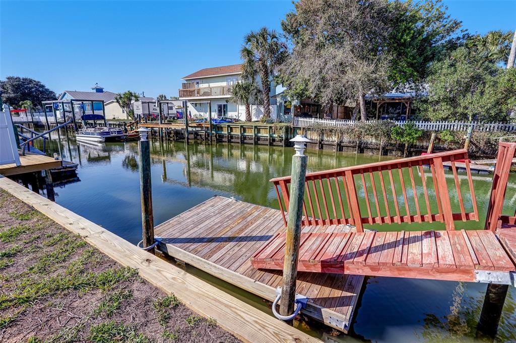 A wooden dock with a red railing extends into a canal near a house — 260 VENTURA ROAD, ST AUGUSTINE, FL