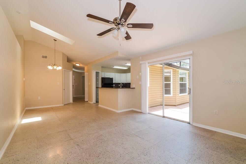 A living room with tile floors, a ceiling fan, and a sliding glass door — 5010 LIGHTERWOOD COURT, OCOEE, FL