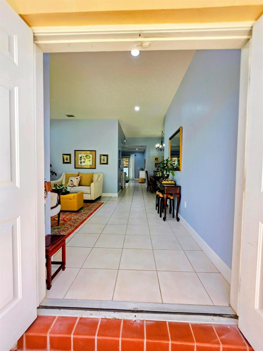 A view from an entryway into a tiled hallway leading to a living room — 14013 N Cypress Cove Circle, Davie FL 33325, DAVIE, FL