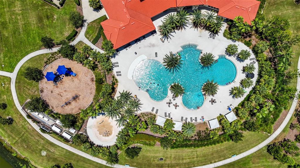 An aerial view shows a swimming pool, a playground, and a building with red roofs — 5413 BADINI WAY, PALMETTO, FL