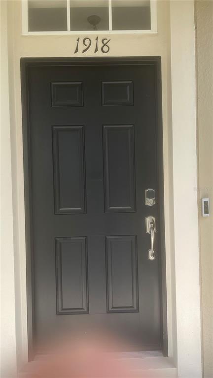 A black front door with a silver handle and keypad lock sits below house number 1918 — 1918 SWEET BIRCH LANE, ORLANDO, FL