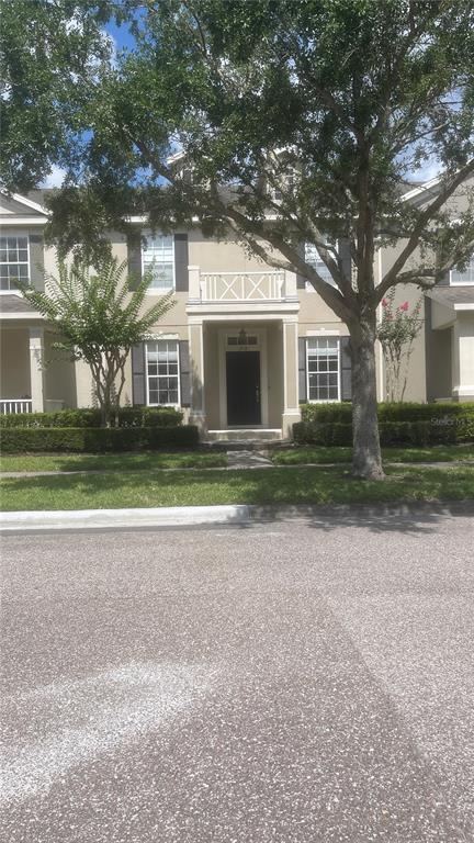 A two-story townhouse exterior features a black front door, a balcony, and manicured hedges — 1918 SWEET BIRCH LANE, ORLANDO, FL
