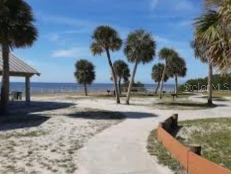 A sandy path leads toward palm trees and a pavilion overlooking the ocean — 6313 OELSNER STREET, NEW PORT RICHEY, FL